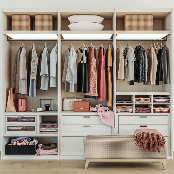 open closet with white drawers and gold accents